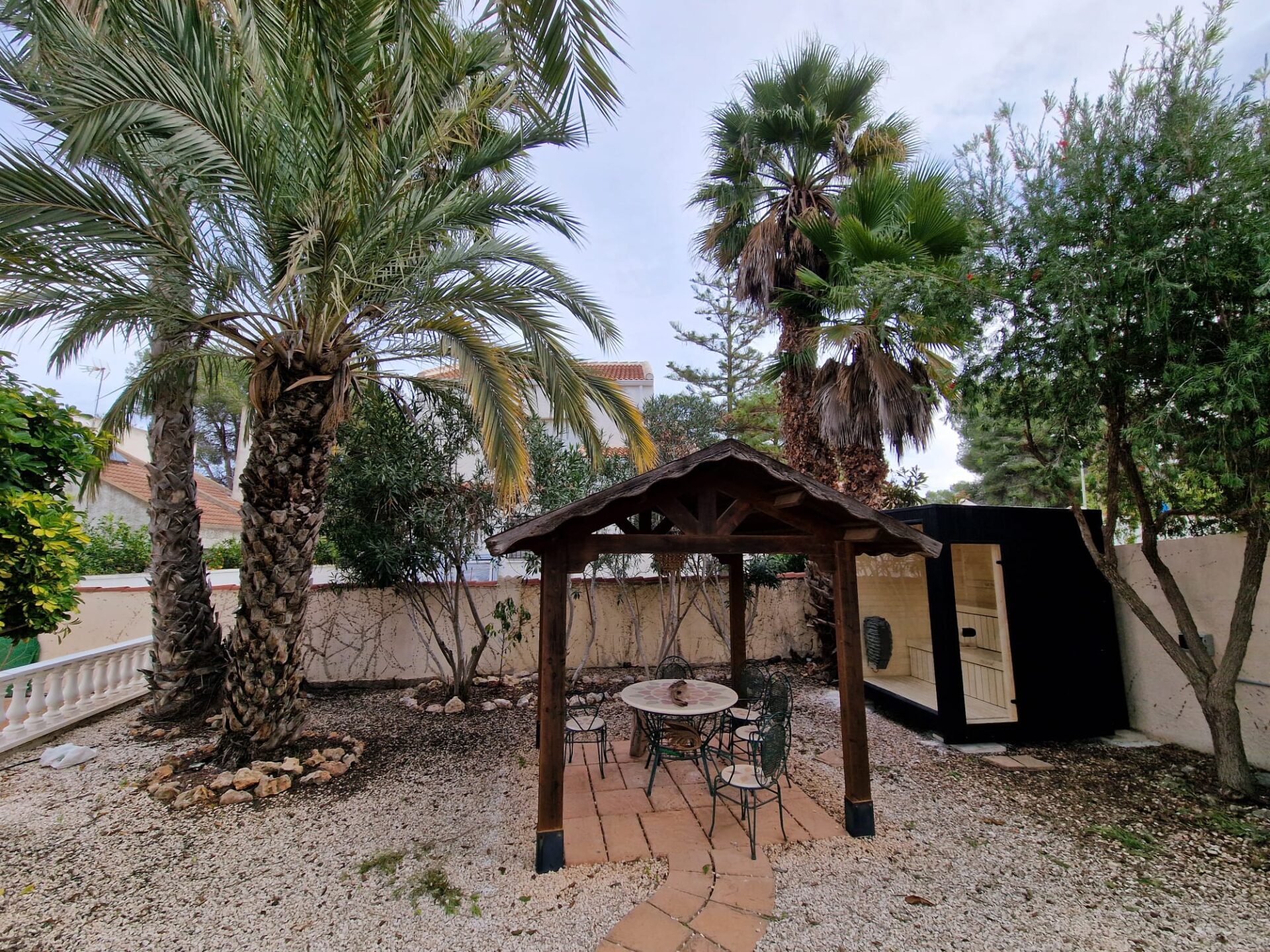 A modern Celsium Wellness sauna surrounded by lush greenery and calm outdoor living